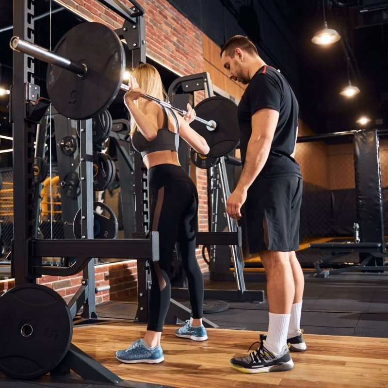 professional-gym-instructor-assisting-woman-at-the-gym-1.jpg